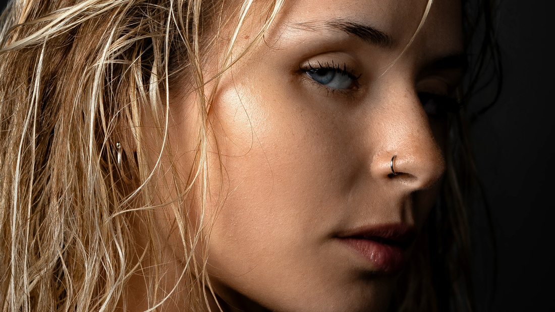 Frau mit ovalem Gesicht und Ohrpiercings