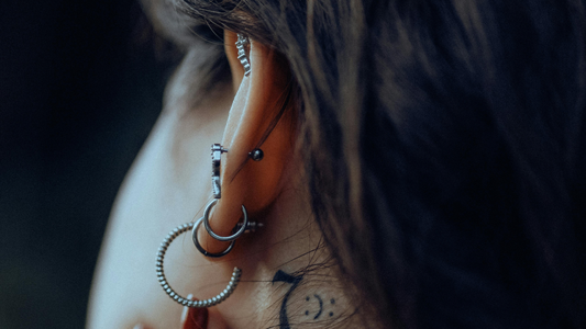 Frau mit verschiedenen Ohrpiercings