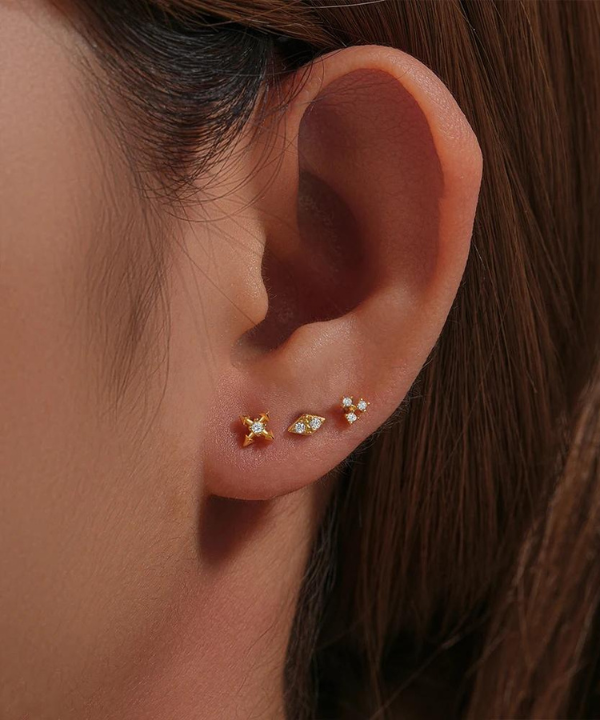 Goldene Eleganz des Forward Helix Piercing Adrianna, ein Hauch von funkelnder Natur.